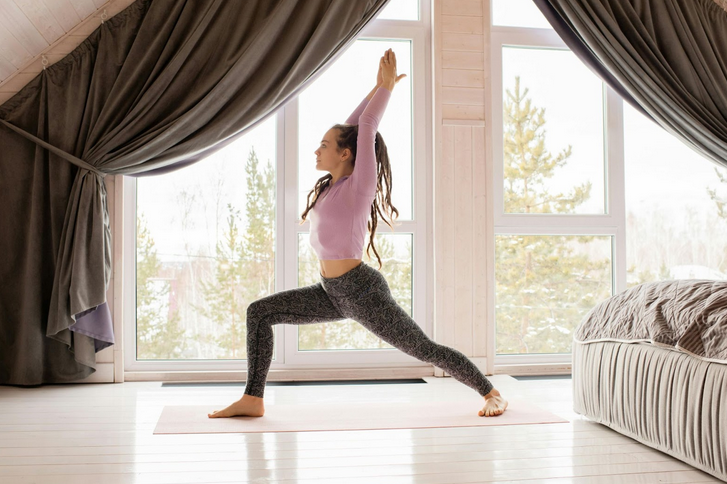 woman stretching near bedroom windows