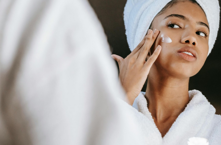 woman applying face cream after bath