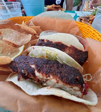 Table of food with a lakeside view at a Put-in-Bay restaurant.