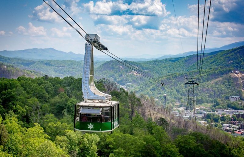 The iconic Ober Mountain Gatlinburg Tram cable car passing high above the mountain forest.
