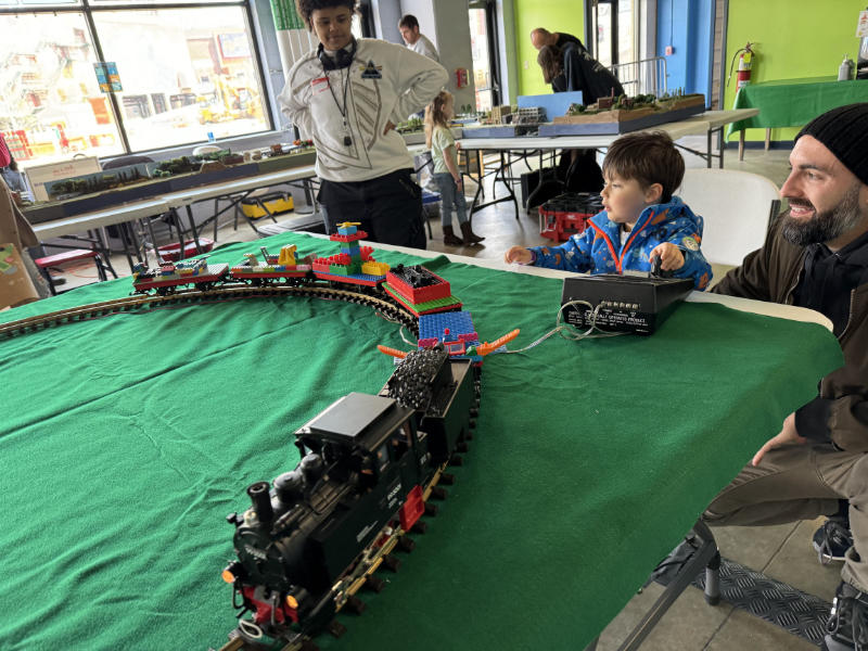 picture of boy and dad with electric train at Enter ticket giveaway for Akron Children's Museum Akron Express Rails & Runways event in Akron, Ohio