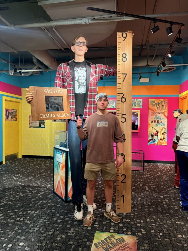 Logan standing next to a life-size statue of Robert Wadlow, the world's tallest man, at Ripley's Gatlinburg.