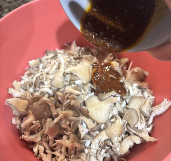 Easy BBQ Pulled Mushroom Sandwiches Vegan Pulled Pork Recipe BBQ sauce pouring over chopped mushrooms for Easy BBQ Pulled Mushroom Sandwiches Vegan Pulled Pork Recipe