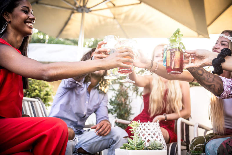 people toasting glasses under tent in outside backyard party
