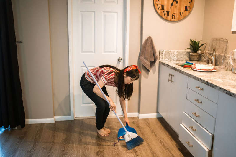 woman sweeping kitchen floor