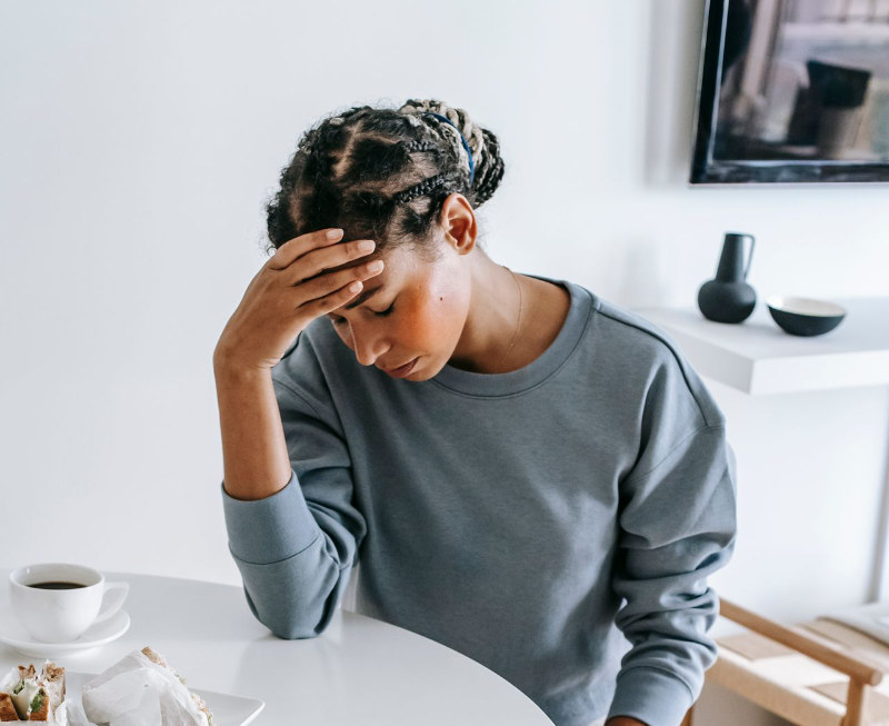 sad woman with hand on forehead